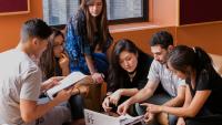 small group of students working together around a computer